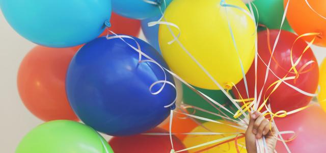 Hand holding a large bundle of balloons